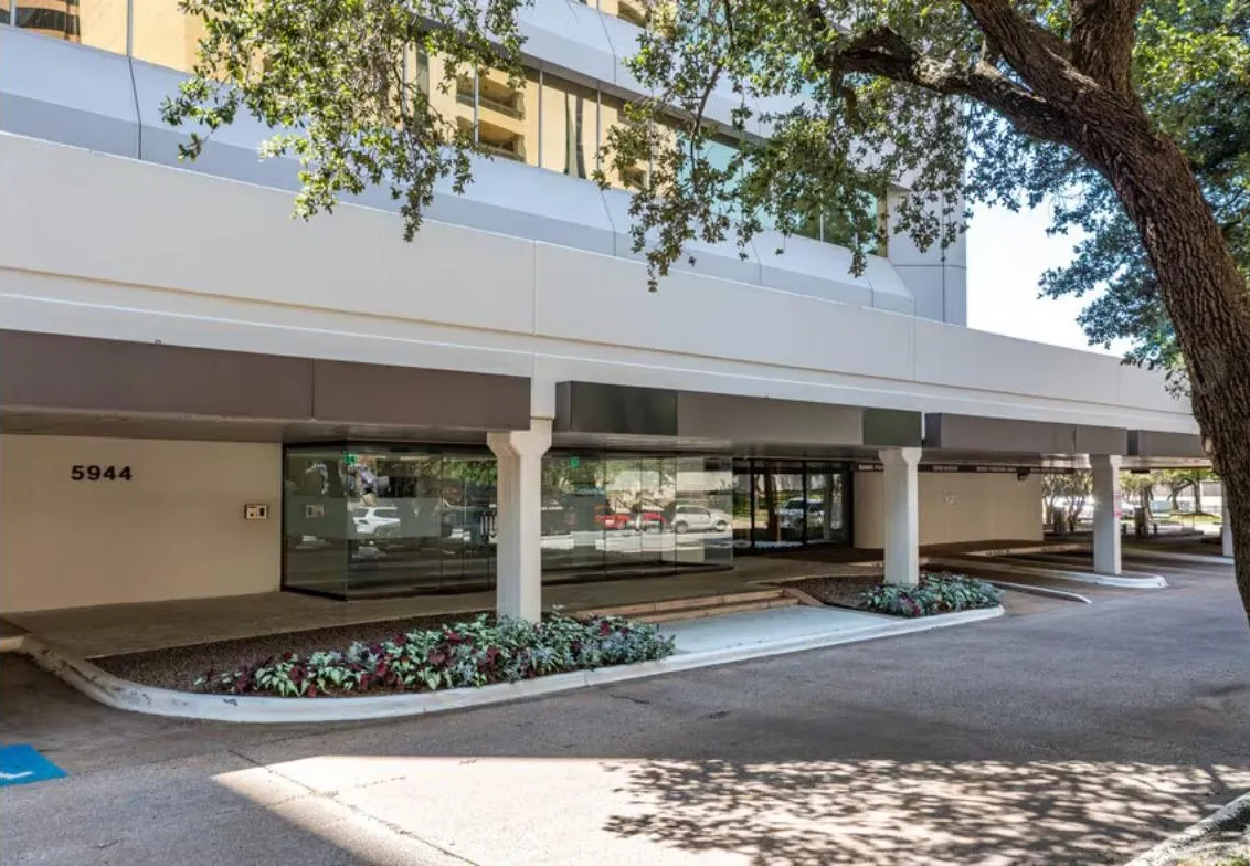 Street entrance of 5944 Luther Lane, with the parking lot beside the building